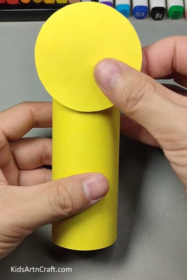 Cutting a circle from yellow paper and pasting it with cardboard roll- Making a Bumblebee Craft from Cardboard Tube for Kids