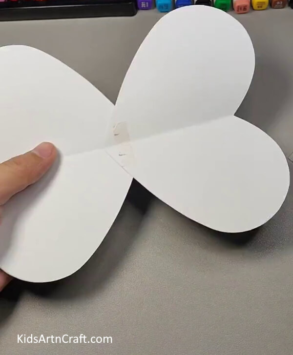 Cutting wings from white paper- Assembling a Bumblebee Art Piece from Cardboard Roll for Young Ones