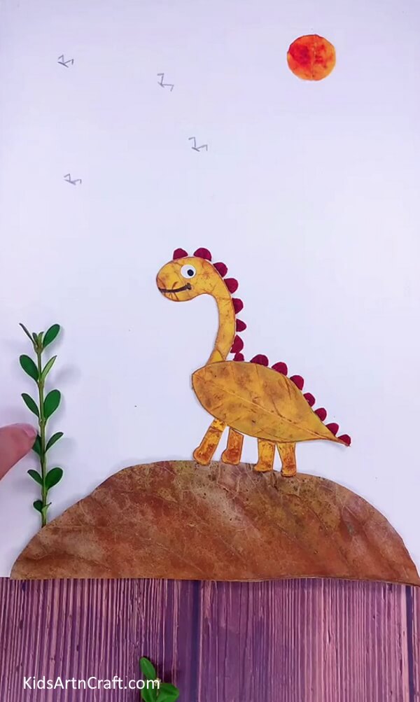 Pasting Small Piece of Plant with glue- This step by step tutorial shows kids how to make a dinosaur out of leaves. 