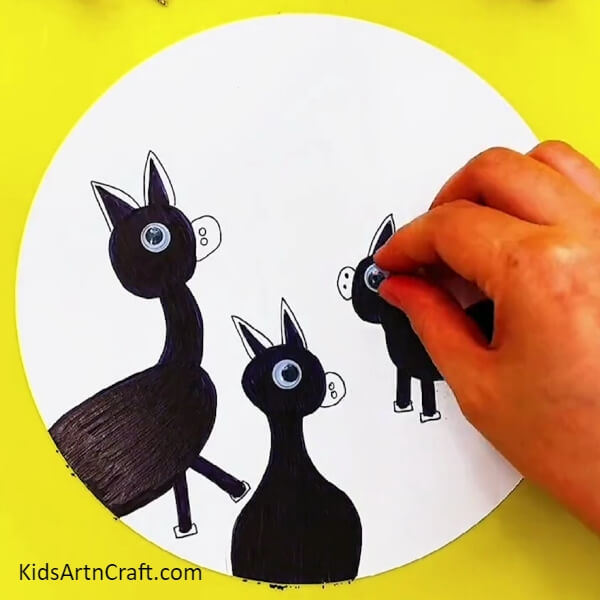 Stick eyes on the donkeys with the help of glue- A Guide to Building a Donkey Painting Art Piece For Little Ones