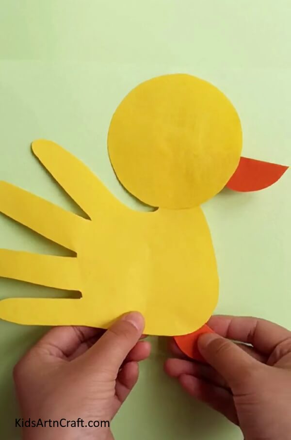 Pasting The Beak And Feet - DIY Baby Duck Handprints - A Simple Task for Little Ones