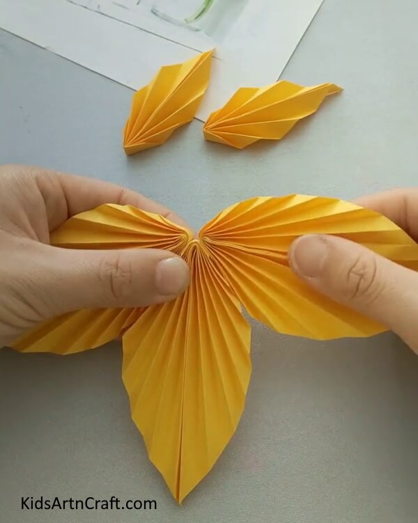 Make Five More Leaf Like Shape With Yellow Craft Paper for Easy Paper Fish- Guidance on creating a paper fish project tailored for children.