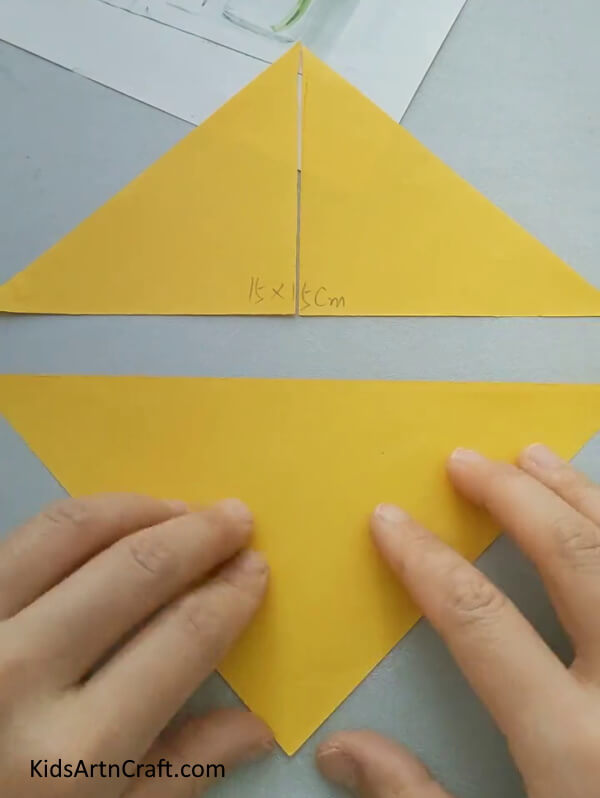 Cut Three Triangles From Yellow Craft Paper with your hand For Kids- An instructional guide to assist with creating a paper fish craft specifically for children. 