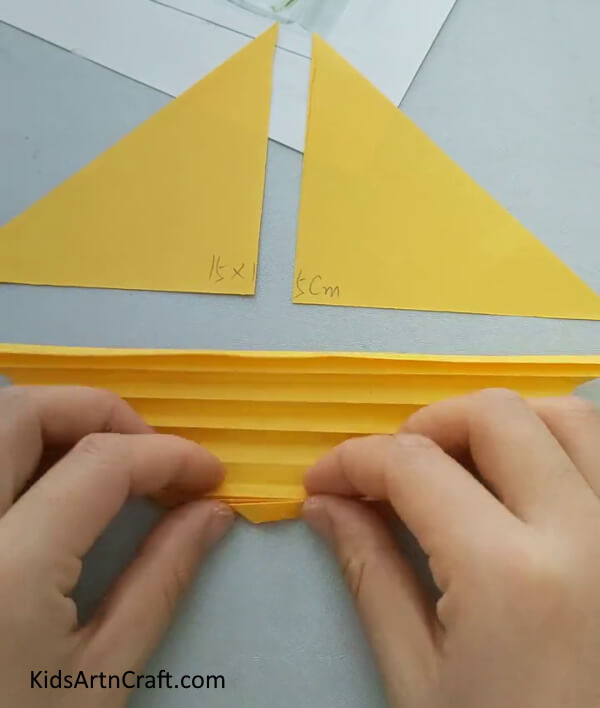 Make Folds On The Big Yellow Triangle equally Easy Paper Fish Craft- A guide for children to make a paper fish craft with ease. 