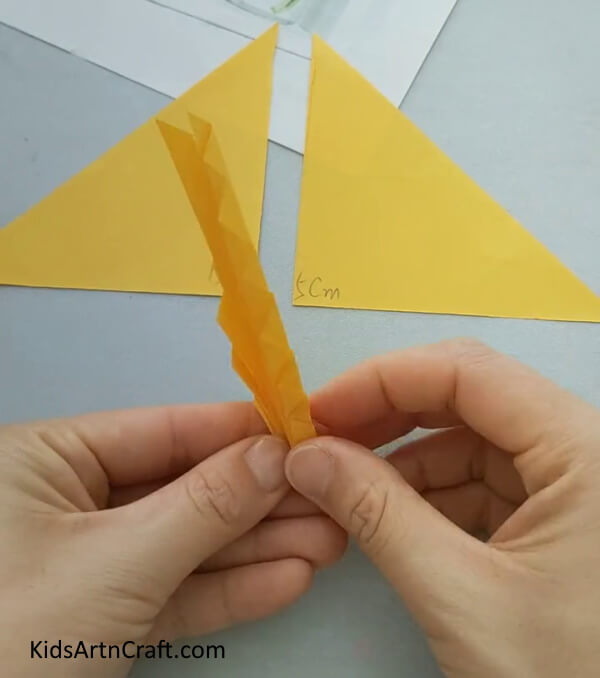 Join Both Corners Of The Folded Triangle Tutorial For Kids- How to make a paper fish craft quickly and simply, for the kids. 