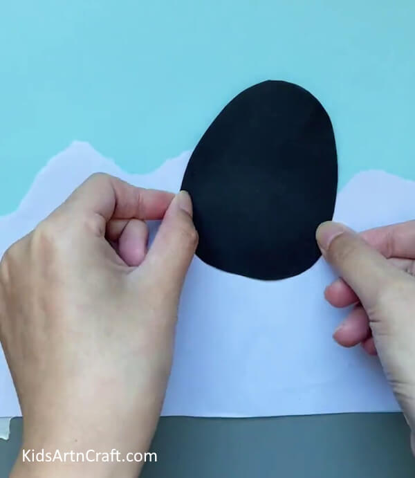 Pasting The Egg Shape-Preschoolers can complete a paper penguin craft without difficulty