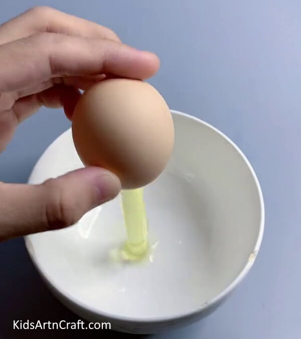 Pouring the Yolk Out of the Egg and Into a Bowl- How to Create a Lamp with Eggshells for Kids 