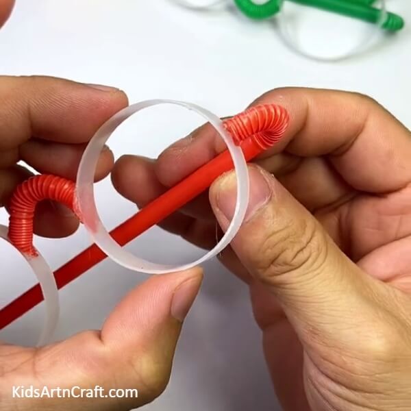 Sticking The Holders To The Frames Of Eye Glass- Make Eye Glasses from a Plastic Bottle and Straw with the help of this step-by-step tutorial.