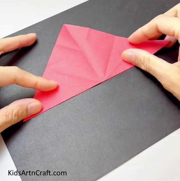 Folding Creases On The Triangle - Make your own fan with bright paper for children.