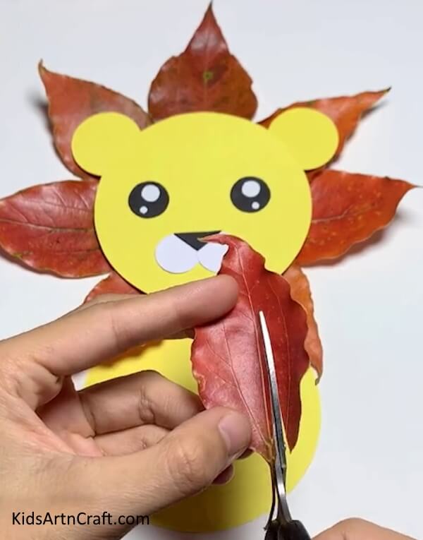 Making The Tail Of The Lion From A Fall Leaf- An easy, child-friendly tutorial on crafting a lion using fall leaves