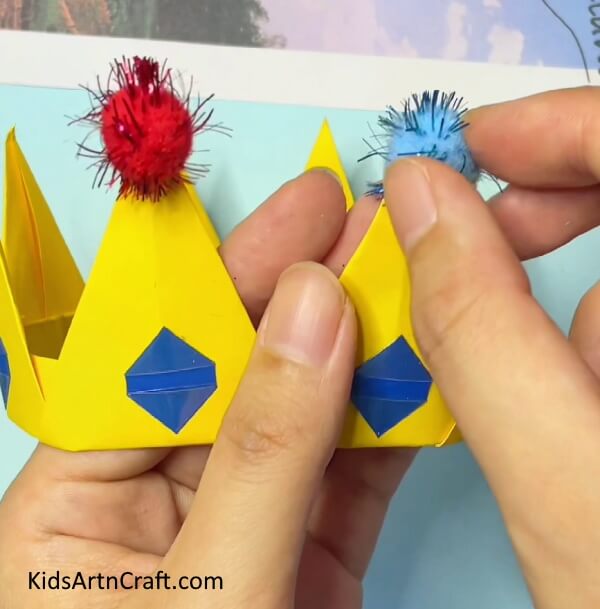 Place the Stringy balls on the tips of your Crown- A Kid-Friendly Tutorial for Making an Origami Paper Crown