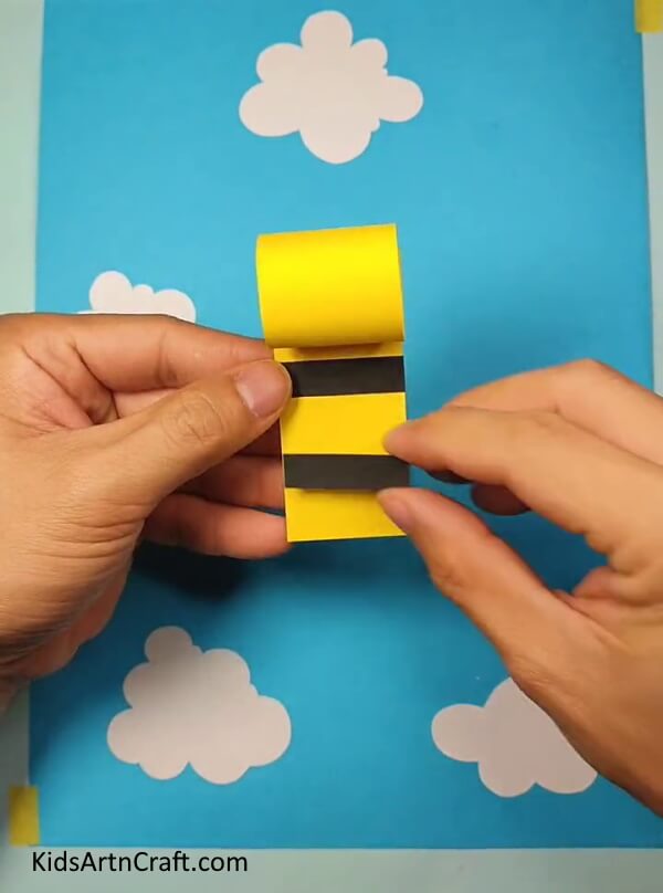 Pasting Black Strips- Follow These Steps to Make a Paper Bee Craft for Kids