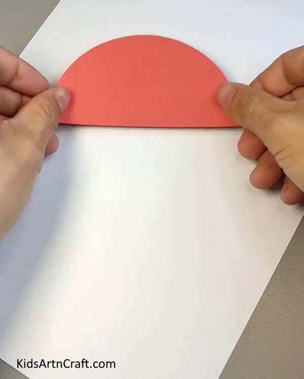 Cutting A Red Semicircle- A simple guide to making a paper car landscape for children.