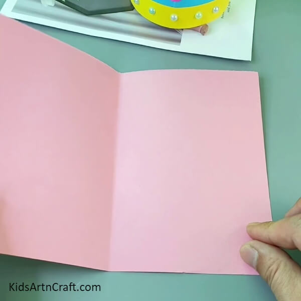 Making A Crease On Pink Paper- Make your own paper crown for kids