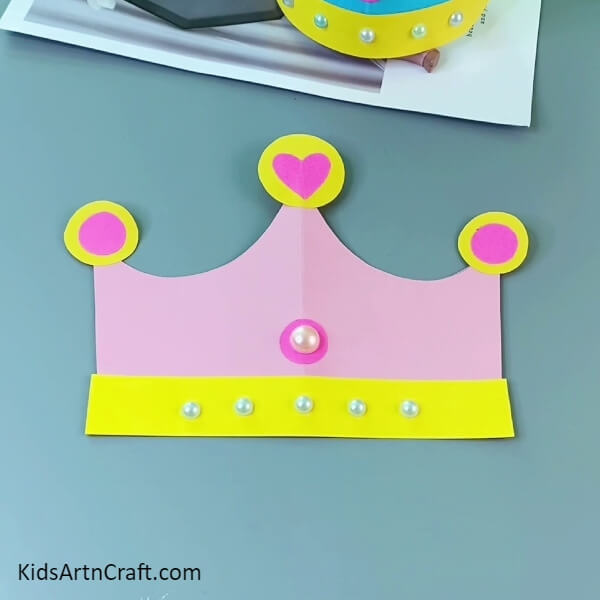 Pasting Craft Pearls- Crafting a paper crown is a fun project for kids