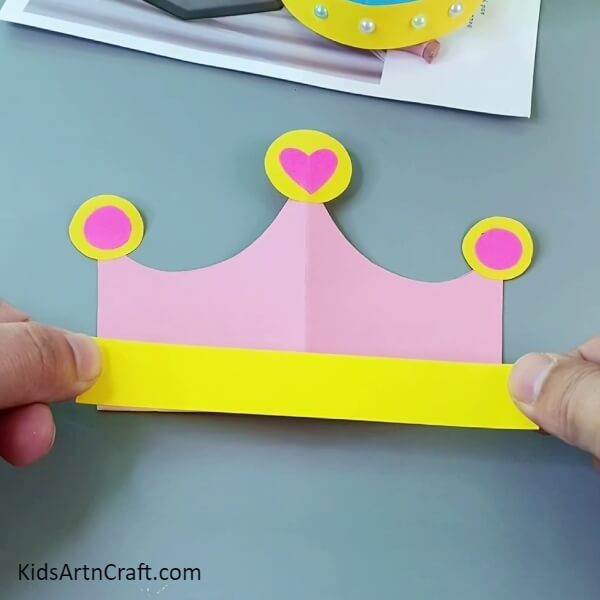 Pasting A Yellow Strip- A creative paper crown activity for kids