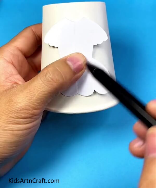 Drawing doll dress on paper cup- This DIY paper cup changing dress doll craft is a great way for kids to have fun.