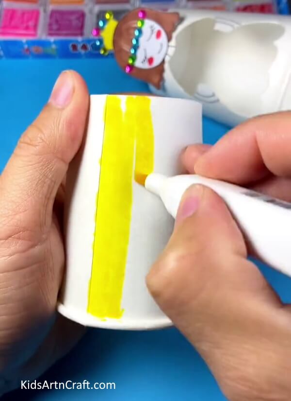 Drawing yellow color design for doll dress- A clever paper cup changing dress doll craft that kids can make themselves.