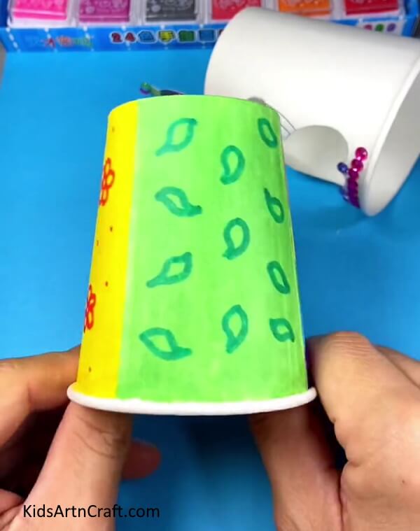 Drawing green color design for doll dress- Kids can make their own paper cup dress-up dolls with this DIY craft.