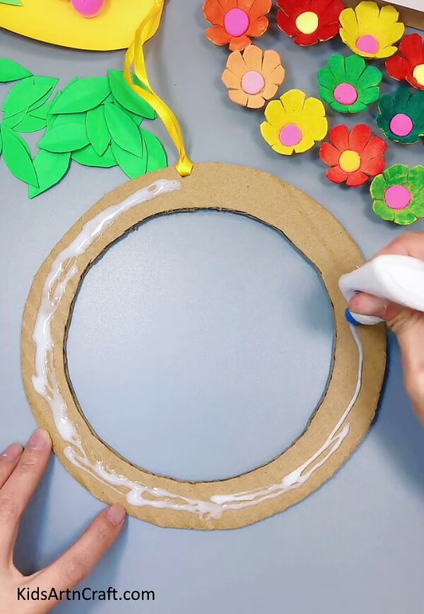Applying Glue On The Cardboard Ring - Assemble a Wall Hanging with a Egg Carton and Paper Flowers for Home Decor
