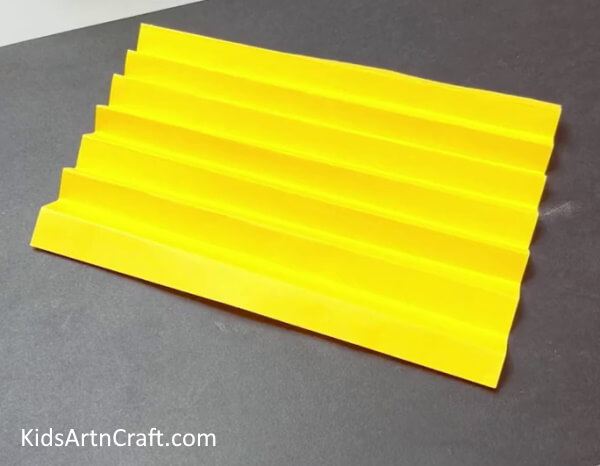 Folding Yellow Paper In A Zigzag Pattern - Making Paper Sunflower Art and Crafts for Children