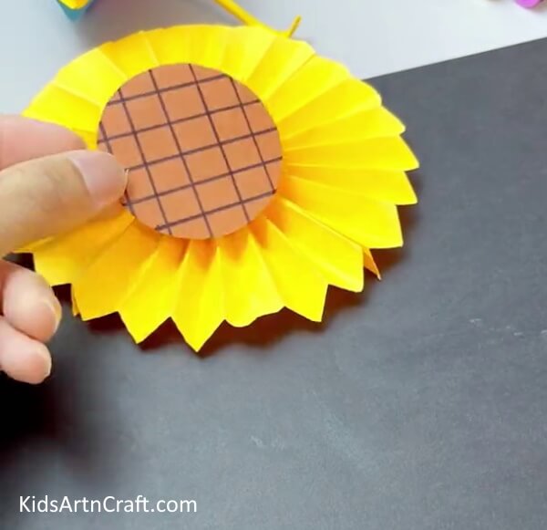 Pasting Brown Circle On The Flower - Sunflower Art and Crafts from Paper with Kids