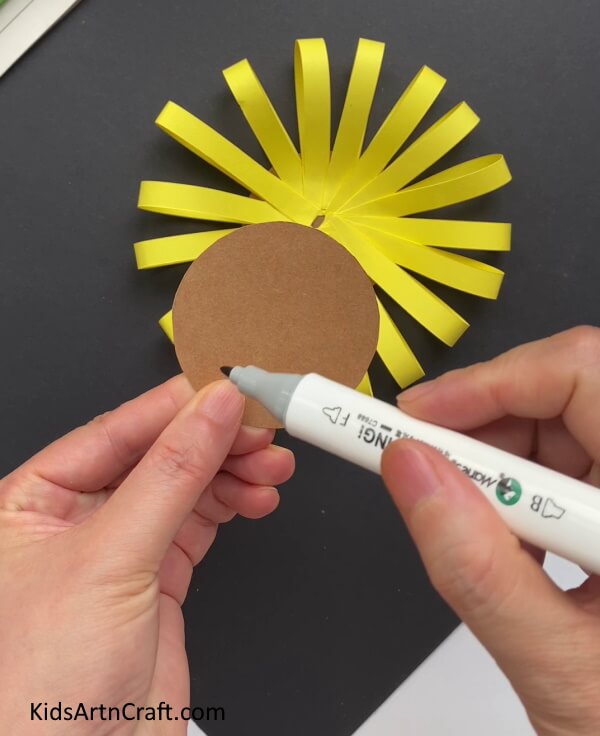 Cutting A Brown Circle And Making A Criss-Cross Pattern -This project allows children to craft sunflowers without difficulty. 