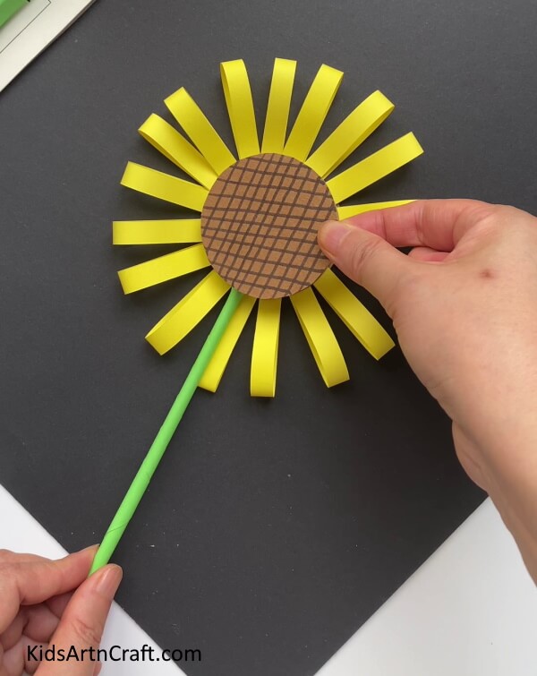 Placing The Brown Circle In The Center Of The Flower - A simple paper crafting exercise for children to construct sunflowers. 