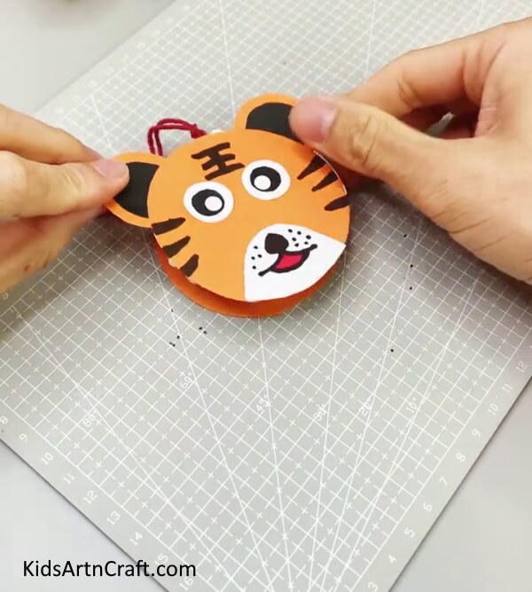 Pasting The Tiger's Face On The Bowl Making a paper tiger wall hanging with no trouble using a DIY activity.