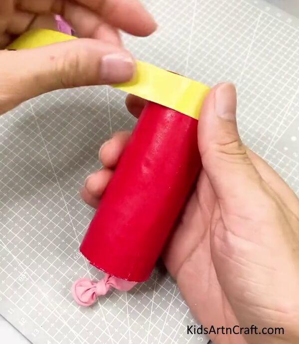 Wrapping Yellow Paper Strip - Discover how to construct a party popper with these steps