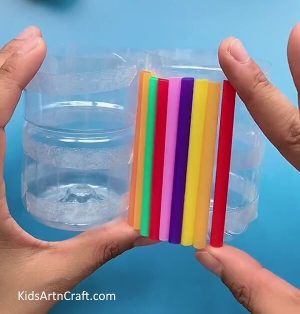 Pasting More Straws-Use plastic bottles and pipe cleaners to craft a pencil holder.