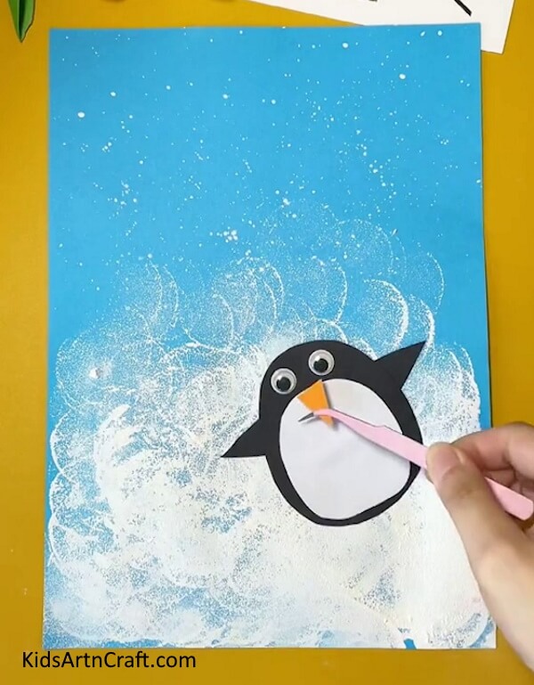 Make a Nose With Orange Craft Paper-Making a penguin craft with this easy-to-follow guide for kids.