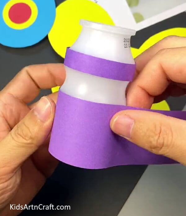 Pasting Another Piece of Violet Paper on Bottle. Craft for children