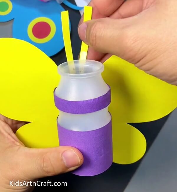 Pasting antennas for bee. Tutorial of Plastic Bottle and Paper Bee Craft for kids