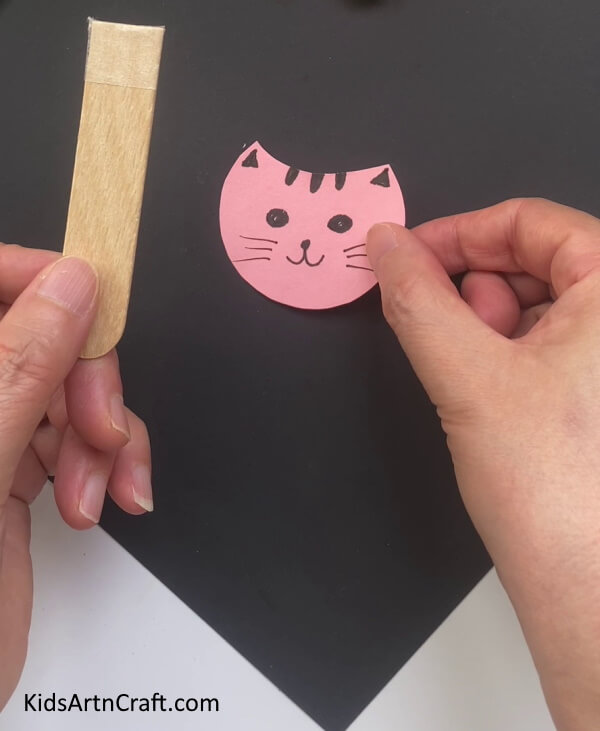 Applying Double-sided Tape On An Ice Cream Stick Learn How to Make a Cat Craft out of Popsicle Sticks and Pipe Cleaners