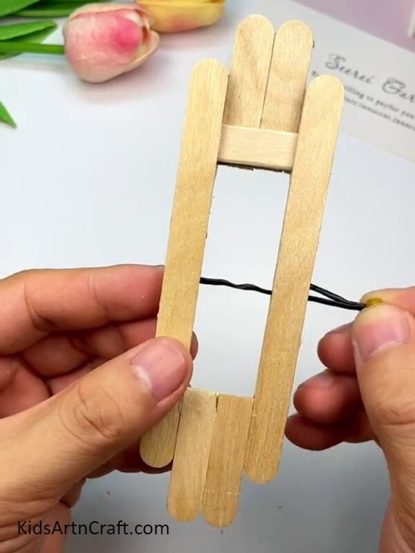 Using the wire as a needle - A Guidebook on Crafting Toys with Popsicle Sticks for Amateurs