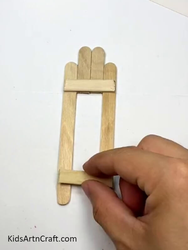 Placing two pieces on top of the sticks - How to Craft Toys with Popsicle Sticks for Novices