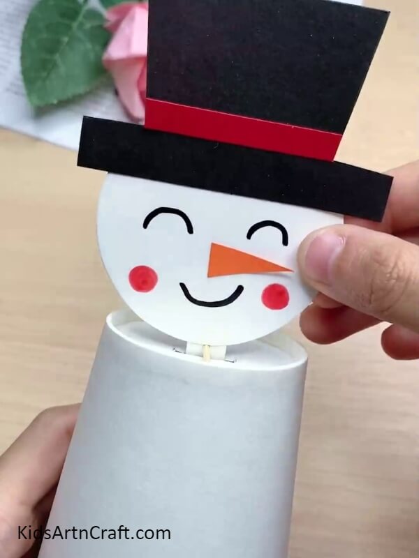 Sticking the Nose- Kids can learn to make a snowman with this paper cup craft tutorial.