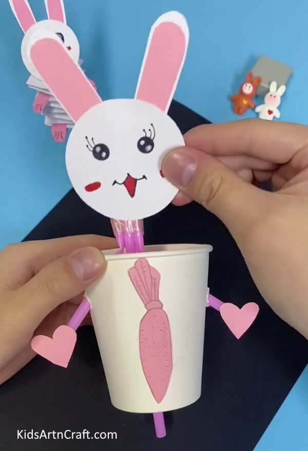 Pasting The Face To The Body Of The Bunny-Make a Bunny Toy with Straws and Paper Cups For Youngsters