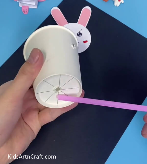 Making A Hole At The Base Of A Paper Cup-Put Together a Bunny Toy with Straws and Paper Cups For Kids