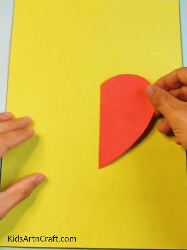 Pasting Red Heart On Yellow Color Craft Paper- Tutorial For Beginners To Make A Strawberry Craft On Their Own
