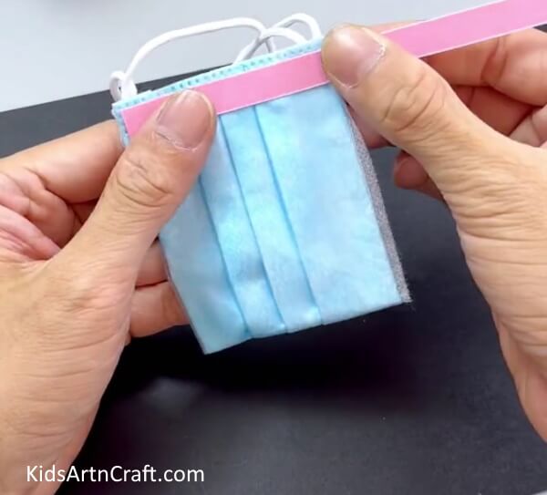 Pasting A Pink Strip Over The Upper End Of The Mask - This is an easy guide to making your own surgical mask pouch.