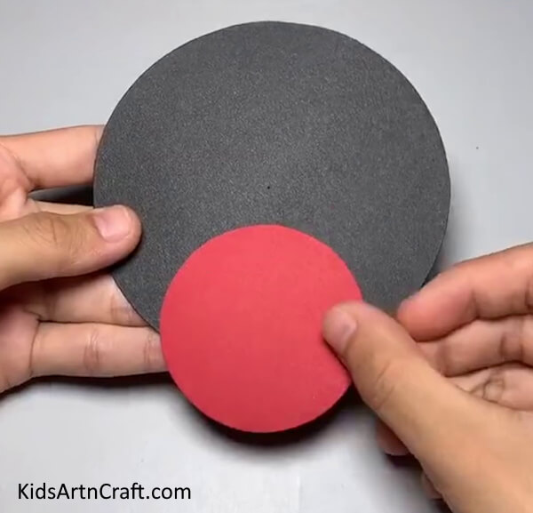 Pasting A Red Circle- An effortless and enjoyable Paper Spider project for children. 