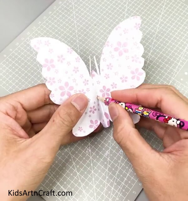 Making A Hole In the Center Of the Butterfly - Make a Butterfly Paper Craft With Kids At Home