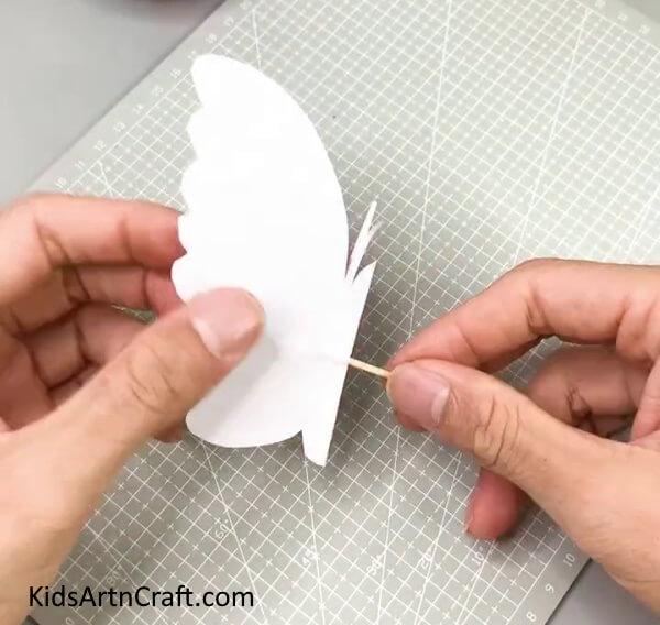 Folding The Butterfly Along The Crease - Create a Butterfly Paper Craft With Children In The House