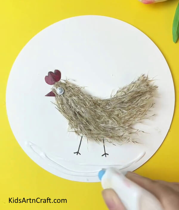 Applying Glue under the Drawing- A Guide to Making a Chicken Craft with Simple Steps for Children 