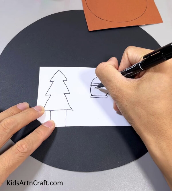 Drawing A Tree And Snowman On A White Paper - Quick and easy Christmas crafts for kids to try at home