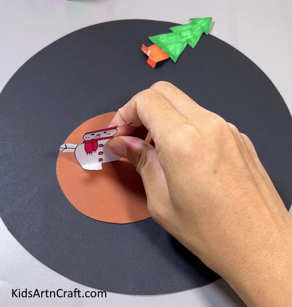Pasting Snowman On  Circle - Quick and easy Christmas projects for kids to do in the residence