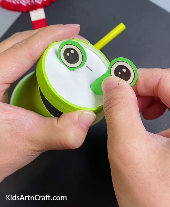 Insert eye cutouts in the cuts- Constructing a Frog Puppet Toy With a Paper Cup For Youngsters