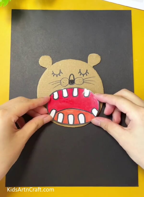 Pasting The Mouth On The Head-A simple foam net lion craft project for kids